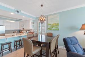 eine Küche und ein Esszimmer mit Tisch und Stühlen in der Unterkunft San Carlos 1501 in Gulf Shores + 30 Fotos