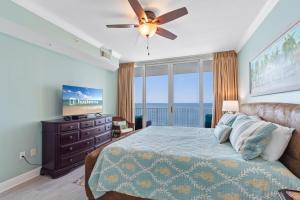 Schlafzimmer mit einem Bett, einem Deckenventilator und einem TV in der Unterkunft San Carlos 1501 in Gulf Shores