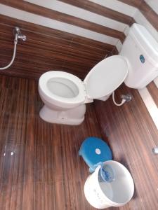 a bathroom with a toilet and a blue scale at Swami's Yatri nivas in Akalkot