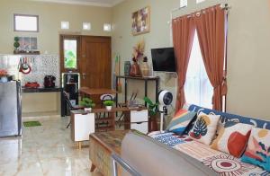 a living room with a couch and a kitchen at Brojos Homestay near Malioboro in Yogyakarta