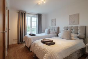 a bedroom with two beds and a window at Mackie Residence - SJA Stays - 3 Bed Apartment with parking in Westhill 