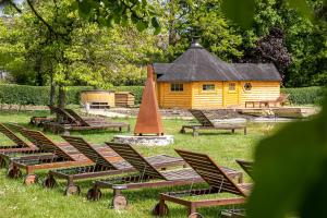 a group of lounge chairs and a cabin in a park at Land van Engelingen in Helshoven