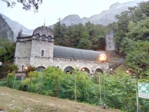 an old stone building on a hill with mountains in the background at Corte Valdadige in Brentino Belluno +32 photos
