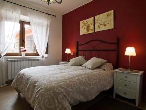 a bedroom with a large bed with red walls at Casa Castillo I in Arenas de Iguña +25 photos