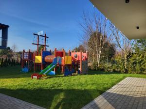 a playground with a slide in the grass at Apartamenty Łuska w Dębinie in Debina