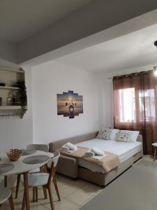 ネオス・マルマラスにあるApartman SIDRO Spacious with BIG balconyのベッドとテーブルと椅子のある寝室 +18枚の写真