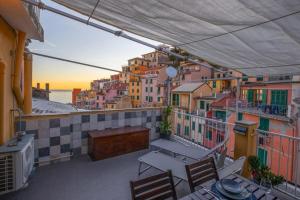 un balcone con tavoli e sedie in un edificio di House dell'amore a Riomaggiore