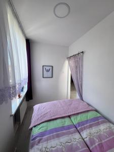 a bedroom with a bed with a colorful blanket at Apartament Lawendowy in Skarżysko-Kamienna