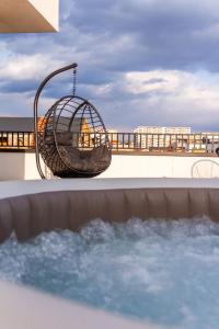 a bird cage hanging over a swimming pool at Skylark - Cairo Penthouse cu Jacuzzi si Vedere la Munte in Braşov