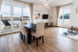 a dining room with a table and chairs and a balcony at Skylark - Cairo Penthouse cu Jacuzzi si Vedere la Munte in Braşov