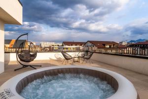 a hot tub on the roof of a balcony at Skylark - Cairo Penthouse cu Jacuzzi si Vedere la Munte in Braşov