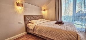Un dormitorio con una cama con un osito de peluche encima. en Genys luxury apartamentai 1, en Palanga