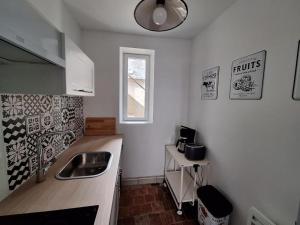 a small kitchen with a sink and a window at Les Remparts 1 in La Charité-sur-Loire