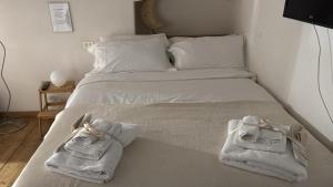 een wit bed met handdoeken erop bij LaFilo Apartment 2 in Milaan