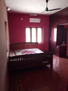 a bedroom with a bed in a room with purple walls at Tharissu Potta Rassey Farm House in Kollengode