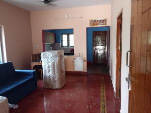 a living room with a couch and a kitchen at Tharissu Potta Rassey Farm House in Kollengode