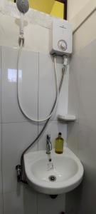 a bathroom with a sink and a shower head at Kikay's Bed & Breakfast in Tagaytay