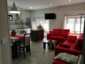 a living room with a red couch and a kitchen at Casa Castillo II in Arenas de Iguña +18 photos