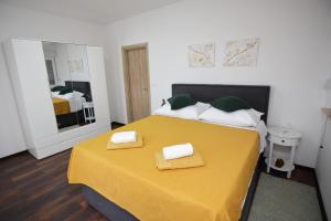 a bedroom with a yellow bed with two towels on it at Villa Marana in Čavoglave +33 photos