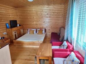 a room with a bed and a couch in a cabin at Kolibe Ćorić in Mojkovac