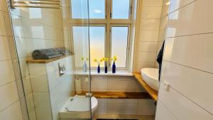 ein Badezimmer mit Toilette, Fenster und Waschbecken in der Unterkunft APPLE BLOSSOM - Boutique Guest House - near Rønne and Beach in Rønne + 134 Fotos