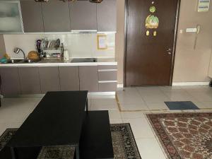 a kitchen with a black table and a brown door at Regalia Hostel Free Infinity Skypool Free in Kuala Lumpur +9 photos