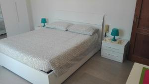 1 dormitorio con 1 cama y mesita de noche con 2 lámparas en Appartamento Sezzate 40, en Strada