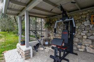 a gym with a bike parked next to a stone wall at Glicine by Garda FeWo in Tignale