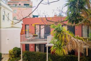 an apartment building with a balcony and palm trees at Jardim da Lapa by Shiadu in Lisbon