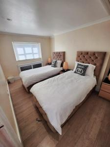 a bedroom with two beds and a window at Gucci flat in Knightsbridge in London