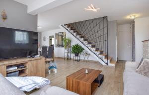 a living room with a couch and a staircase at L'Air de Caen in Esquay-Notre-Dame