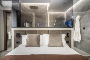 Karma6Rooms - in Sicilia nel centro di Catania في كاتانيا: غرفة نوم بسرير كبير مع ملاءات ووسائد بيضاء