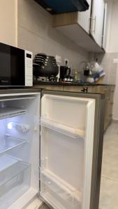 a kitchen with an empty refrigerator in a kitchen at Studio Apartment - The Aviv Kitisuru near KSG in Nairobi