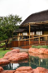 a building with a pond in front of it at The Springbok Lodge in Nambiti Private Game Reserve