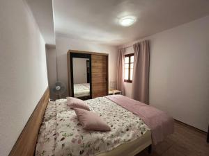 a bedroom with a bed with pillows and a mirror at Apartament Marina Cullera in Cullera