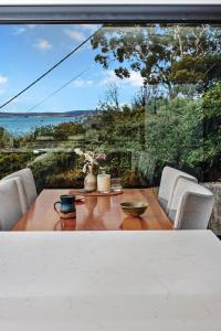 a dining table with a view of the ocean at Fabulous, New, Well Appointed Beach House in Kingston Beach
