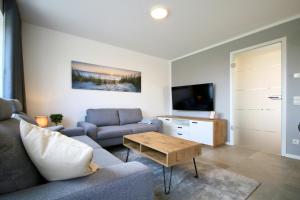 una sala de estar con un sofá y una mesa en Am Dahmer Leuchtturm 23c, en Dahme