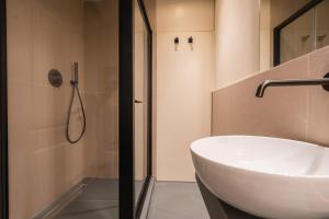 ein Badezimmer mit einem weißen Waschbecken und einer Dusche in der Unterkunft Maison Luxury Suite - Duomo in Florenz + 32 Fotos