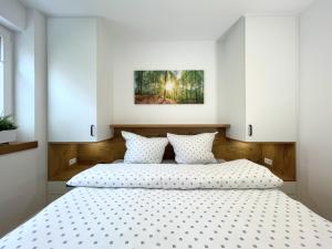 Un dormitorio con una gran cama blanca con almohadas blancas. en Am Dahmer Leuchtturm 23c, en Dahme