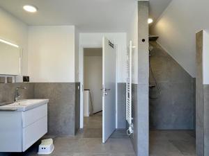 y baño con lavabo y ducha. en Am Dahmer Leuchtturm 23c, en Dahme 28 fotos más