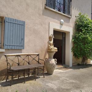 a statue of a woman sitting on a vase next to a bench at les jardins de la gardiole in Balaruc-le-Vieux