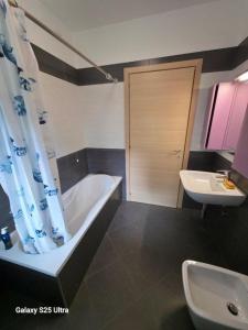 a bathroom with a bath tub and a sink at Macrinum - LE DUNE in Silvi Marina