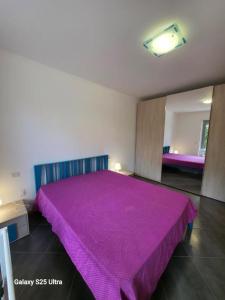 a bedroom with a large purple bed in a room at Macrinum - LE DUNE in Silvi Marina