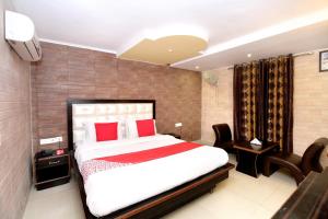a bedroom with a large bed with red pillows at Hotel O Continental Inn in Chandīgarh +37 photos