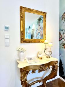 an ornate console table with a mirror on a wall at Sissis Paradies Appartement mit Balkon & Flussblick- Das Alpenzeit im Zentrum mit Parkplatz in Bad Aussee +68 photos