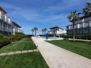 a pathway leading to a resort with palm trees at Macrinum - LE DUNE in Silvi Marina
