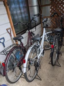 two bikes are parked next to a building at Guest house AIZU First in Aizuwakamatsu