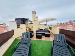 a patio with chairs and an umbrella on a roof at Vera Albacora de Luxe in Vera