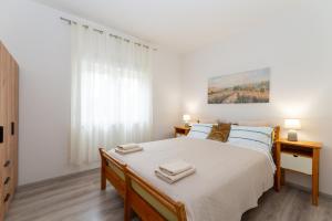 a bedroom with a large bed with two towels on it at Villa K&F Borik in Zadar