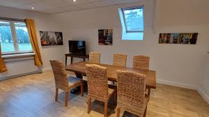 a dining room with a wooden table and chairs at La Bonnerie-Le Pupitre La Bouëxière in La Bouexière